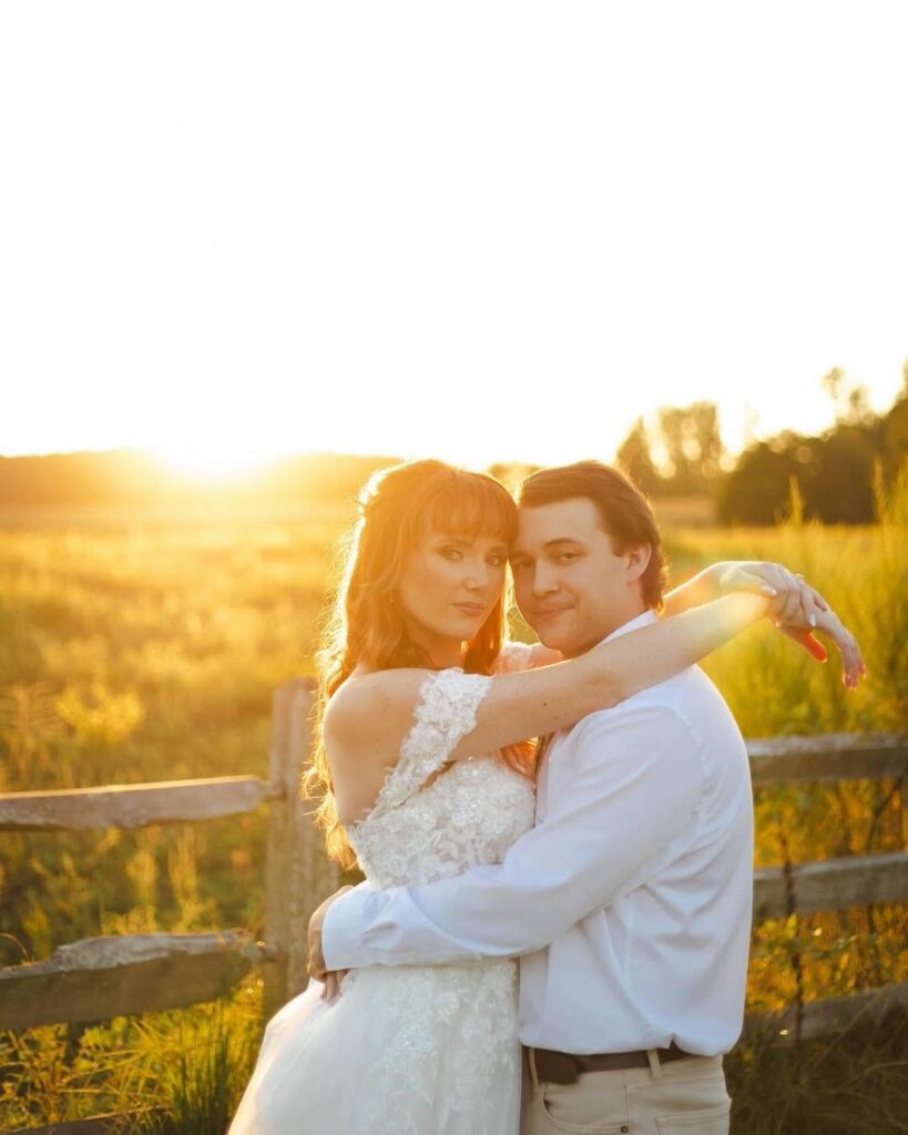 Couple at golden hour by the field fence